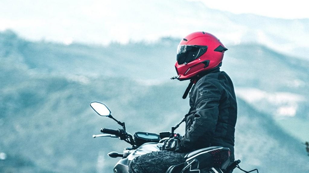Gambar seseorang memakai helm saat berkendara motor